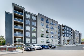 A modern apartment complex with a parking lot in front.